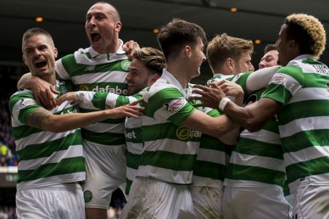 Celtic's Callum McGregor celebrates with teammates after scoring his sides' third goal of the game during their Scottish Premiership soccer match against Rangers at the Ibrox Stadium, Glasgow, Scotland, Saturday, April 29, 2017. Celtic dished out one last humiliation to hapless Rangers as their 5-1 win at Ibrox took them to within five games of an unbeaten domestic campaign. The Parkhead faithful lapped up every moment of this season's sixth and final Old Firm duel as Brendan Rodgers' undefeated troops outclassed a feeble Rangers line-up from start to finish. (Craig Watson/PA via AP)