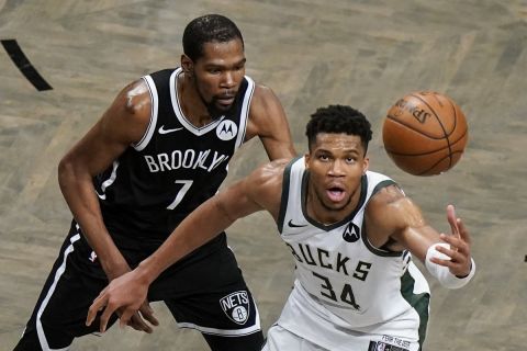 Brooklyn Nets' Kevin Durant (7) defends against Milwaukee Bucks' Giannis Antetokounmpo (34) during overtime of Game 7 of a second-round NBA basketball playoff series Saturday, June 19, 2021, in New York. (AP Photo/Frank Franklin II)