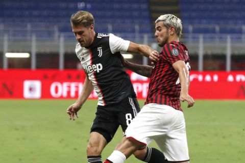 AC Milan's Theo Hernandez, right, fights for the ball with Juventus' Aaron Ramsey during the Serie A soccer match between AC Milan and Juventus at the San Siro stadium, in Milan, Italy, Tuesday, July 7, 2020. (AP Photo/Antonio Calanni)