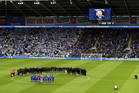 Leicester City players and staff stand with Cardiff City players and match officials during a minute's silence in memory of the victims of the Leicester City helicopter crash which included Chairman Vichai Srivaddhanaprabha during the English Premier League soccer match between Cardiff City and Leicester City at the Cardiff City Stadium, Cardiff. Wales. Saturday Nov. 3, 2018. (Simon Galloway/PA via AP)/PA via AP)
