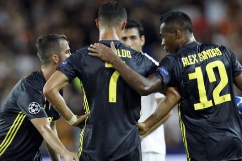 Juventus forward Cristiano Ronaldo talks to teammates Alex Sandro, right, and Miralem Pjanic after receiving a red card during the Champions League, group H soccer match between Valencia and Juventus, at the Mestalla stadium in Valencia, Spain, Wednesday, Sept. 19, 2018. (AP Photo/Alberto Saiz)