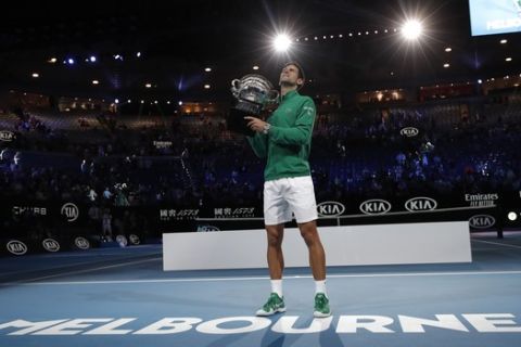 Serbia's Novak Djokovic holds the Norman Brookes Challenge Cup after defeating Austria's Dominic Thiem in the men's singles final of the Australian Open tennis championship in Melbourne, Australia, Monday, Feb. 3, 2020. (AP Photo/Lee Jin-man)