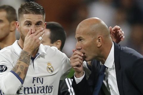 Real Madrid's head coach Zinedine Zidane gives tactical advise to Real Madrid's Sergio Ramos during a Champions League, Group F soccer match between Real Madrid and Sporting, at the Santiago Bernabeu stadium in Madrid, Spain, Wednesday, Sept. 14, 2016. (AP Photo/Daniel Ochoa de Olza)