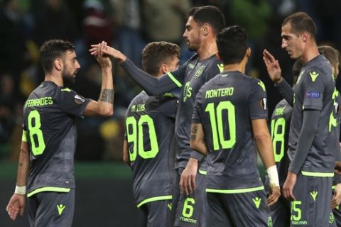 Sporting's Bruno Fernandes, left, celebrates after scoring his side's third goal during the Europa League group E soccer match between Sporting CP and Vorskla Poltava at the Alvalade stadium in Lisbon, Thursday, Dec. 13, 2018. (AP Photo/Armando Franca)