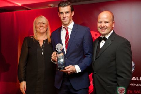 CARDIFF, WALES - Monday, October 6, 2014: Wales' Gareth Bale is presented with the Fans' Player of the Year Award by Chief-Executive Jonathan Ford and Vauxhall's Cheryl Stibbs at the FAW Footballer of the Year Awards 2014 held at the St. David's Hotel. (Pic by David Rawcliffe/Propaganda)