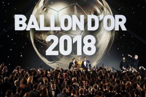 Olympique Lyonnais' Ada Hegerberg with the Women's Ballon d'Or, center, poses with Real Madrid's Luka Modric, with the Ballon d'Or, left, and Paris St Germain's Kylian Mbappe with the Kopa Trophy, right, during the Golden Ball award ceremony at the Grand Palais in Paris, France, Monday, Dec. 3, 2018. Awarded every year by France Football magazine since Stanley Matthews won it in 1956, the Ballon d'Or, Golden Ball for the best player of the year will be given to both a woman and a man. (AP Photo/Christophe Ena)