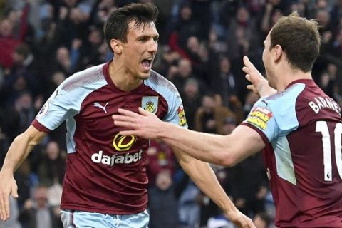 Burnley's Jack Cork, left, celebrates scoring his side's first goal of the game against Swansea City during the English Premier League soccer match at Turf Moor, Burnley, England, Saturday Nov. 18, 2017. (Anthony Devlin/PA via AP)