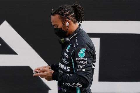 Mercedes driver Lewis Hamilton of Britain, arrives for the end season picture ahead of the Emirates Formula One Grand Prix, at the Yas Marina racetrack in Abu Dhabi, United Arab Emirates, Sunday, Dec. 12, 2021. (AP Photo/Hassan Ammar)