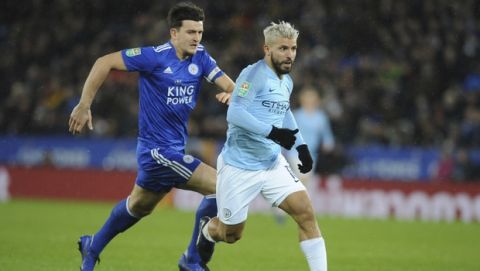 Manchester City's Sergio Aguero, right, runs on to shoot at goal as Leicester City's Harry Maguire attempts to tackle during the English League Cup quarterfinal soccer match at the King Power stadium in Leicester, England, Tuesday, Dec.18, 2018. (AP Photo/Rui Vieira)
