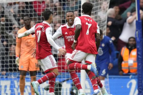 Arsenal's Bukayo Saka, third from left back to the camera, celebrates with teammates after scoring the opening goal during the English Premier League soccer match between Chelsea and Arsenal at Stamford Bridge Stadium in London, Sunday, Nov. 6, 2022. (AP Photo/Kirsty Wigglesworth)