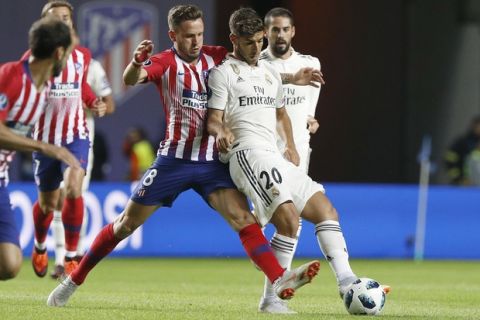 Atletico's Saul Niguez, left, and Real Madrid's Marco Asensio challenge for the ball during the UEFA Super Cup final soccer match between Real Madrid and Atletico Madrid at the Lillekula stadium in Tallinn, Estonia, Wednesday, Aug. 15, 2018. (AP Photo/Mindaugas Kulbis)