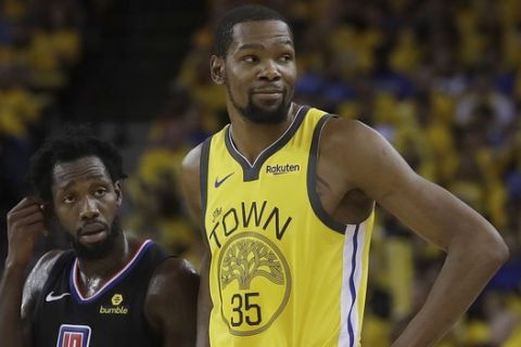 Golden State Warriors forward Kevin Durant (35) stands next to Los Angeles Clippers guard Patrick Beverley (21) during the second half of Game 2 of a first-round NBA basketball playoff series in Oakland, Calif., Monday, April 15, 2019. (AP Photo/Jeff Chiu)