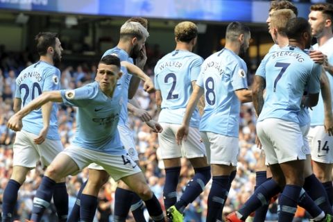Manchester City's Phill Foden, left, celebrates his goal against Tottenham during the English Premier League soccer match between Manchester City and Tottenham Hotspur at Etihad stadium in Manchester, England, Saturday, April 20, 2019. (AP Photo/Rui Vieira)