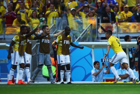 BELO HORIZONTE, BRAZIL - JUNE 14: Teofilo Gutierrez of Colombia (R) runs to his teammates on the sideline after scoring his teams second goal during the 2014 FIFA World Cup Brazil Group C match between Colombia and Greece at Estadio Mineirao on June 14, 2014 in Belo Horizonte, Brazil.  (Photo by Ian Walton/Getty Images)