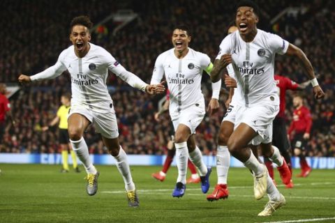 Paris Saint Germain's Presnel Kimpembe, right, celebrates after scoring the opening goal the game during the Champions League round of 16 soccer match between Manchester United and Paris Saint Germain at Old Trafford stadium in Manchester, England, Tuesday, Feb. 12,2019.(AP Photo/Dave Thompson)
