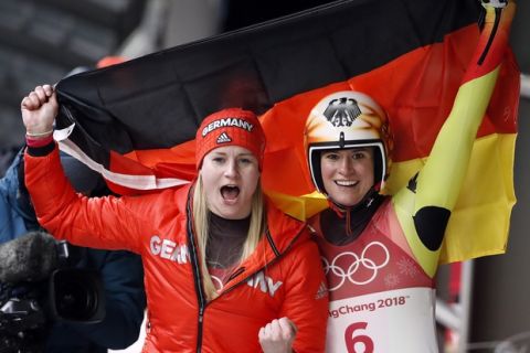 Natalie Geisenberger of Germany, right, celebrates her gold medal win as Dajana Eitberger of Germany celebrates her silver medal win in the finish area after the women's luge final at the 2018 Winter Olympics in Pyeongchang, South Korea, Tuesday, Feb. 13, 2018. (AP Photo/Andy Wong)