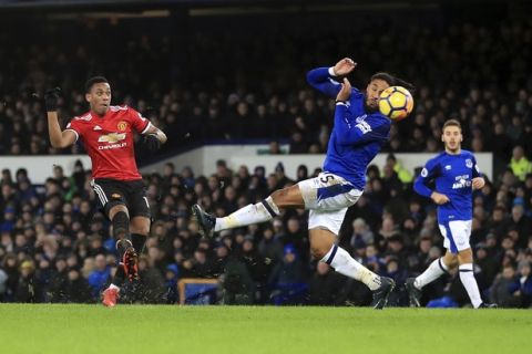 Manchester United's Anthony Martial, left, scores his side's first goal of the game, during the English Premier League soccer match between Everton and Manchester United, at Goodison Park, in Liverpool, England, Monday, Jan. 1, 2018. (Peter Byrne/PA via AP)