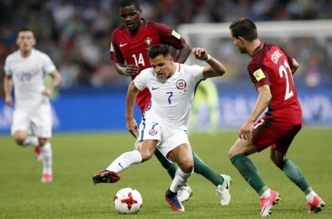 Chile's Alexis Sanchez, center is challenged by Portugal's Cedric Soares, right, and William Carvalho, during the Confederations Cup, semifinal soccer match between Portugal and Chile, at the Kazan Arena, Russia, Wednesday, June 28, 2017. (AP Photo/Pavel Golovkin)