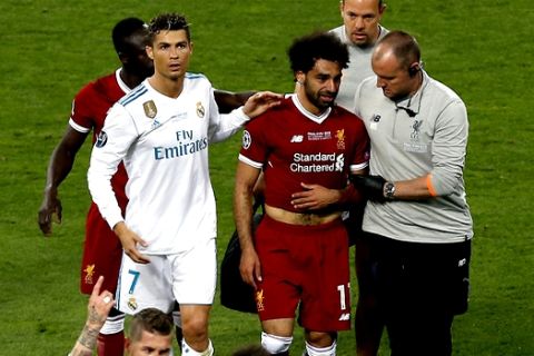 Real Madrid's Cristiano Ronaldo, left, walks next to Liverpool's Mohamed Salah, 2nd right, as Salah leaves the pitch during the Champions League Final soccer match between Real Madrid and Liverpool at the Olimpiyskiy Stadium in Kiev, Ukraine, Saturday, May 26, 2018. (AP Photo/Darko Vojinovic)