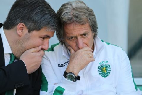 Sporting's new coach Jorge Jesus listens to club president Bruno de Carvalho, left, before a soccer match against AS Roma to present to supporters the Sporting team for the new season at the Alvalade stadium in Lisbon, Saturday, Aug. 1, 2015. (AP Photo/Armando Franca)