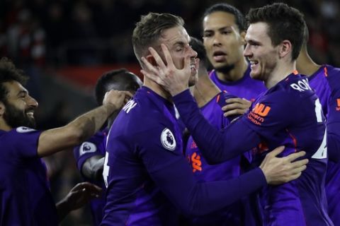 Liverpool's Jordan Henderson, center, celebrates with teammates after scoring his side's third goal during the English Premier League soccer match between Southampton and Liverpool at St Mary's stadium in Southampton, England Friday, April 5, 2019. (AP Photo/Kirsty Wigglesworth)
