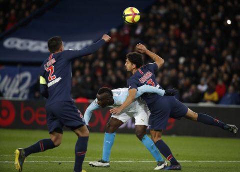 Marseille's Mario Balotelli, center, PSG's Thiago Silva , left, and PSG's Marquinhos , right, vie for the ball during their French League One soccer match between Paris-Saint-Germain and Olympique Marseille at the Parc des Princes stadium in Paris, Sunday, March 17, 2019. (AP Photo/Christophe Ena)