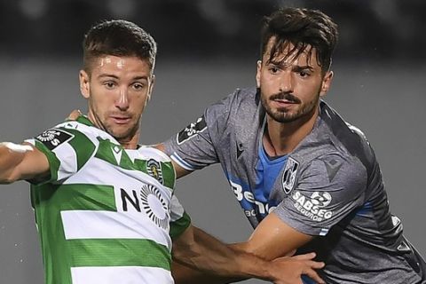 Vitoria de Guimaraes' Pepe Rodrigues, right, fights for the ball with Sporting's Luciano Vietto during the Portuguese League soccer match between Vitoria SC and Sporting CP in Guimaraes, Portugal, Thursday, June 4, 2020. The Portuguese League soccer matches resumed Wednesday without spectators because of the coronavirus pandemic. (Hugo Delgado/Pool via AP)