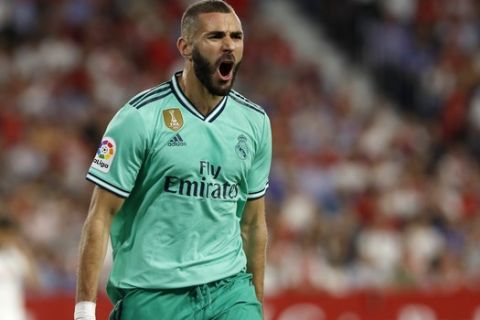Real Madrid's Karim Benzema celebrates after scoring his side's opening goal during the Spanish La Liga soccer match between Sevilla and Real Madrid at the Ramon Sanchez Pizjuan stadium in Seville, Spain, Sunday, Sept. 22, 2019. (AP Photo/Miguel Morenatti)