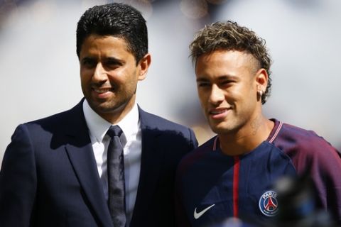 Brazilian soccer star Neymar poses with PSG president Nasser Ghanim Al-Khelaïfi at the Parc des Princes stadium in Paris, Saturday, Aug. 5, 2017, during his official presentation to fans ahead of Paris Saint-Germain's season opening match against Amiens. Neymar would not play in the club's season opener as the French football league did not receive the player's international transfer certificate before Friday's night deadline. The Brazil star became the most expensive player in soccer history after completing his blockbuster transfer from Barcelona for 222 million euros ($262 million) on Thursday. (AP Photo/Francois Mori)