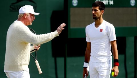 Novak Djokovic of Serbia, right, speaks with his coach Boris Becker before resuming his men's singles match against Sam Querrey of the U.S on day six of the Wimbledon Tennis Championships in London, Saturday, July 2, 2016. (AP Photo/Ben Curtis)
