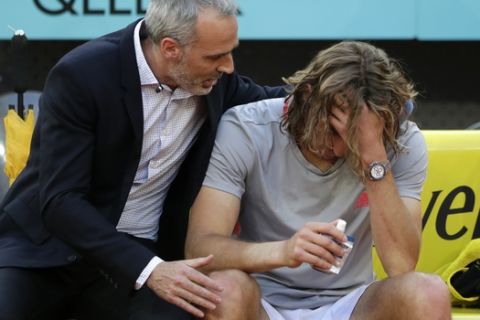 Former Spanish tennis player Alex Corretja, left, consoles Greece's Stefanos Tsitsipas after he lost the final of the Madrid Open tennis tournament against Serbia's Novak Djokovic in Madrid, Spain, Sunday, May 12, 2019. (AP Photo/Bernat Armangue)