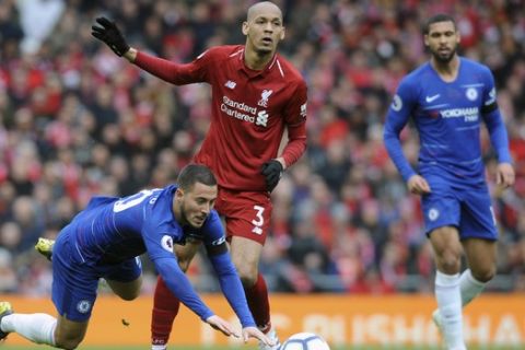 Chelsea's Eden Hazard, left, duels for the ball with Liverpool's Fabinho during the English Premier League soccer match between Liverpool and Chelsea at Anfield stadium in Liverpool, England, Sunday, April 14, 2019. (AP Photo/Rui Vieira)