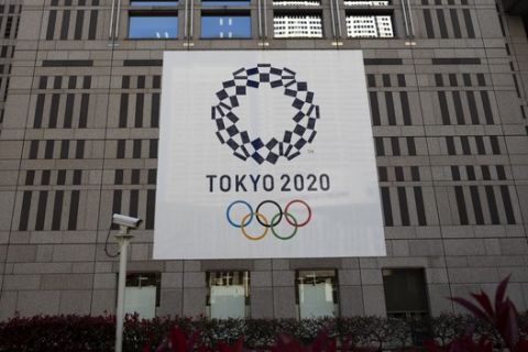 A banner promoting the Tokyo 2020 Olympics hands on the facade of the Tokyo Metropolitan Government building Wednesday, March 25, 2020, in Tokyo. Not even the Summer Olympics could withstand the force of the new coronavirus. After weeks of hedging, the IOC took the unprecedented step of postponing the world's biggest sporting event, a global extravaganza that's been cemented into the calendar for more than a century. (AP Photo/Jae C. Hong)