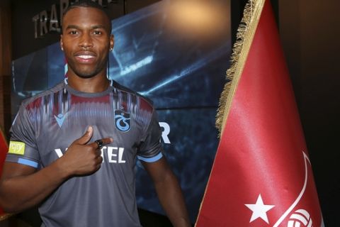 In this Sunday Aug. 25, 2019 photo made available by Trabzonspor, English footballer Daniel Sturridge poses for photographs after signing for Trabzonspor in the Black Sea city of Trabzon, Turkey. Sturridge, the former Liverpool and England striker had joined joining Turkish Super Lig side Trabzonspor. The 29-year-old recently served a six-week ban for breaching the FA's (Football Association) betting rules, having been accused of providing information to family and friends relating to a possible move to Sevilla in Jan. 2018. (Trabzonspor via AP)