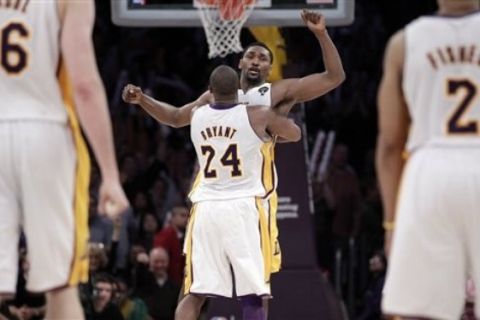 Los Angeles Lakers forward Ron Artest, center right, is hugged by teammate Kobe Bryant after Artest made a basket against the Phoenix Suns in triple overtime of an NBA basketball game in Los Angeles,  Tuesday, March 22, 2011. The Lakers won 139-137 in triple overtime. (AP Photo/Jae C. Hong)