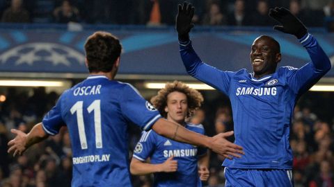 Chelsea's French-born Senegalese striker Demba Ba (R) celebrates with teammate Brazilian midfielder Oscar (L) after scoring the opening goal during the UEFA Champions League group E football match between Chelsea and Steaua Bucharest at Stamford Bridge on December 11, 2013.  AFP PHOTO/BEN STANSALL        (Photo credit should read BEN STANSALL/AFP/Getty Images)