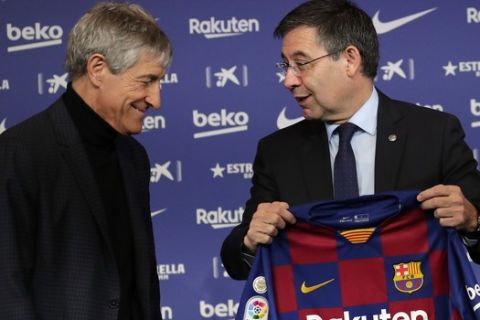 Soccer coach Quique Setien smiles with FC Barcelona's President Josep Maria Bartomeu, right, while being officially introduced as the club's new coach at the Camp Nou stadium in Barcelona, Spain, Tuesday, Jan. 14, 2020. Barcelona made a rare coaching change midway through the season, replacing Ernesto Valverde with former Real Betis manager Quique Setien on Monday. (AP Photo/Emilio Morenatti)