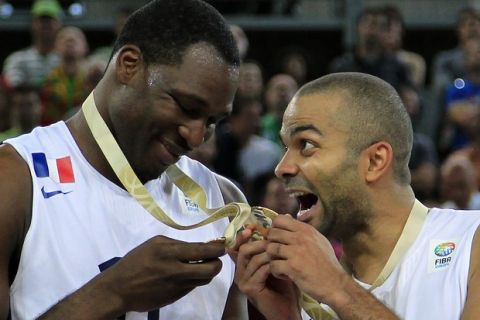 France's Florent Pietrus (L) and Tony Parker show their gold medals after winning their European championship basketball final against Lithuania in Ljubljana's Arena Stozice September 22, 2013. An inspired France won their maiden basketball title in any major competition after overwhelming Lithuania 80-66 in an enthralling European championship final on Sunday.   REUTERS/Antonio Bronic (SLOVENIA - Tags: SPORT BASKETBALL TPX IMAGES OF THE DAY) - RTX13VIL