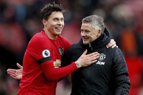 Manchester United's Victor Lindelof, left, and manager Ole Gunnar Solskjaer after the final whistle during the English Premier League soccer match against Watford at Old Trafford, Manchester, England, Sunday Feb. 23, 2020. (Martin Rickett/PA via AP)