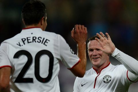 Manchester United's English forward Wayne Rooney (R) celebrates with Manchester United's Dutch forward Robin van Persie after Persie scored during the Champions League Group H football match CFR Cluj vs Manchester United in Cluj Napoca, Romania on October 2, 2012.  AFP PHOTO / DANIEL MIHAILESCU        (Photo credit should read DANIEL MIHAILESCU/AFP/GettyImages)
