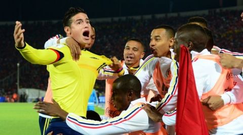 Colombia's James Rodriguez celebrates with teammates after scoring against Chile during their Russia 2018 FIFA World Cup South American Qualifiers football match, in Santiago, on November 12, 2015.    AFP PHOTO / MARTIN BERNETTI
