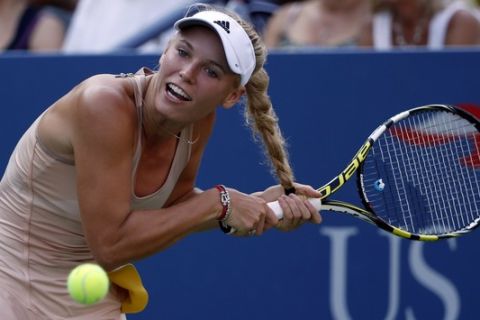 Caroline Wozniacki, of Denmark, gets her hair caught in her racket as she tries to return a shot to Aliaksandra Sasnovich, of Belarus, during the second round of the 2014 U.S. Open tennis tournament, Wednesday, Aug. 27, 2014, in New York. (AP Photo/Kathy Willens)