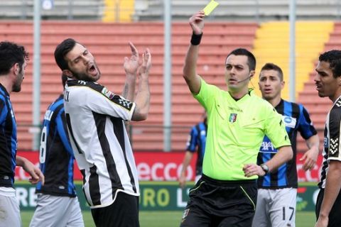 Referee Marco Di Bello, shows a yellow card to Udinese's Maurizio Domizzi, during the Serie A soccer match between Udinese and Atalanta at the Friuli Stadium in Udine, Italy, Sunday, Feb. 23, 2014. (AP Photo/Paolo Giovannini)