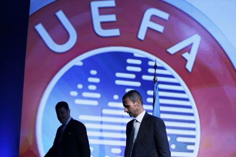 UEFA President-elect  Aleksander Ceferin, right, leaves the podium in front of UEFA  Chief of Press Pedro Pinto after a news conference in Athens, on Wednesday, Sept. 14, 2016. UEFA elected Aleksander Ceferin to succeed Michel Platini as president on Wednesday, replacing one of the greats of soccer with a largely unknown Slovenian lawyer to lead the European game. (AP Photo/Thanassis Stavrakis)