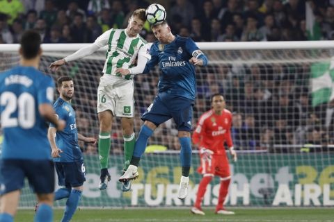 Real Madrid's Sergio Ramos, right, and Betis' Loren, jump for a high ball during La Liga soccer match between Betis and Real Madrid at the Villamarin stadium, in Seville, Spain, on Sunday, Feb. 18, 2018. (AP Photo/Miguel Morenatti)