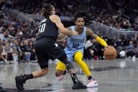 Memphis Grizzlies' Ja Morant (12) makes a move to get around Orlando Magic's Cole Anthony (50) during the second half of an NBA basketball game, Thursday, Jan. 5, 2023, in Orlando, Fla. (AP Photo/John Raoux)