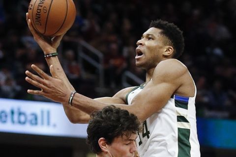 Milwaukee Bucks' Giannis Antetokounmpo (34), from Greece, goes up to shoot against Cleveland Cavaliers' Cedi Osman (16), from Turkey, during the first half of an NBA basketball game Friday, Dec. 14, 2018, in Cleveland. (AP Photo/Ron Schwane)
