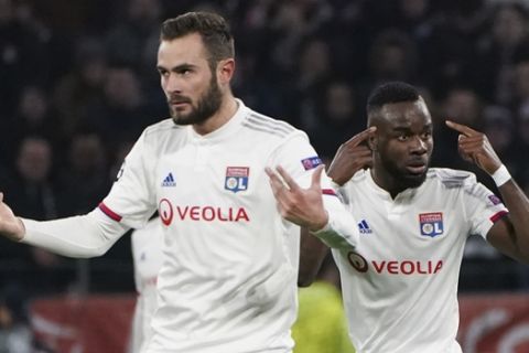 Lyon's Maxwel Cornet, right, gestures as he celebrates with teammate Lucas Tousart, left, who scored his side's first goal during a round of sixteen, first leg, soccer match between Lyon and Juventus at the at the Lyon Olympic Stadium in Decines, outside Lyon, France, Wednesday, Feb. 26, 2020. (AP Photo/Laurent Cipriani)