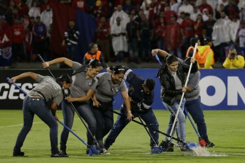 Ground staff mop the field after a Copa Libertadores Group 3 soccer match between Argentina's River Plate and Colombia's Deportivo Independiente Medellin was suspended due to heavy rain at the Atanasio Girardot stadium in Medellin, Colombia, Wednesday, March 15, 2017. (AP Photo/Ricardo Mazalan)