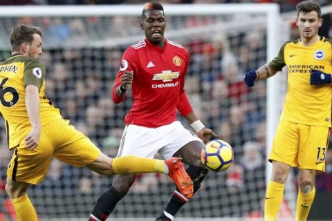 Brighton & Hove Albion's Dale Stephens, left, in action with Manchester United's Paul Pogba, centre, and Brighton & Hove Albion's Pascal Gross, right, during the English Premier League soccer match at Old Trafford in Manchester, England, Saturday Nov. 25, 2017. (Martin Rickett/PA via AP)
